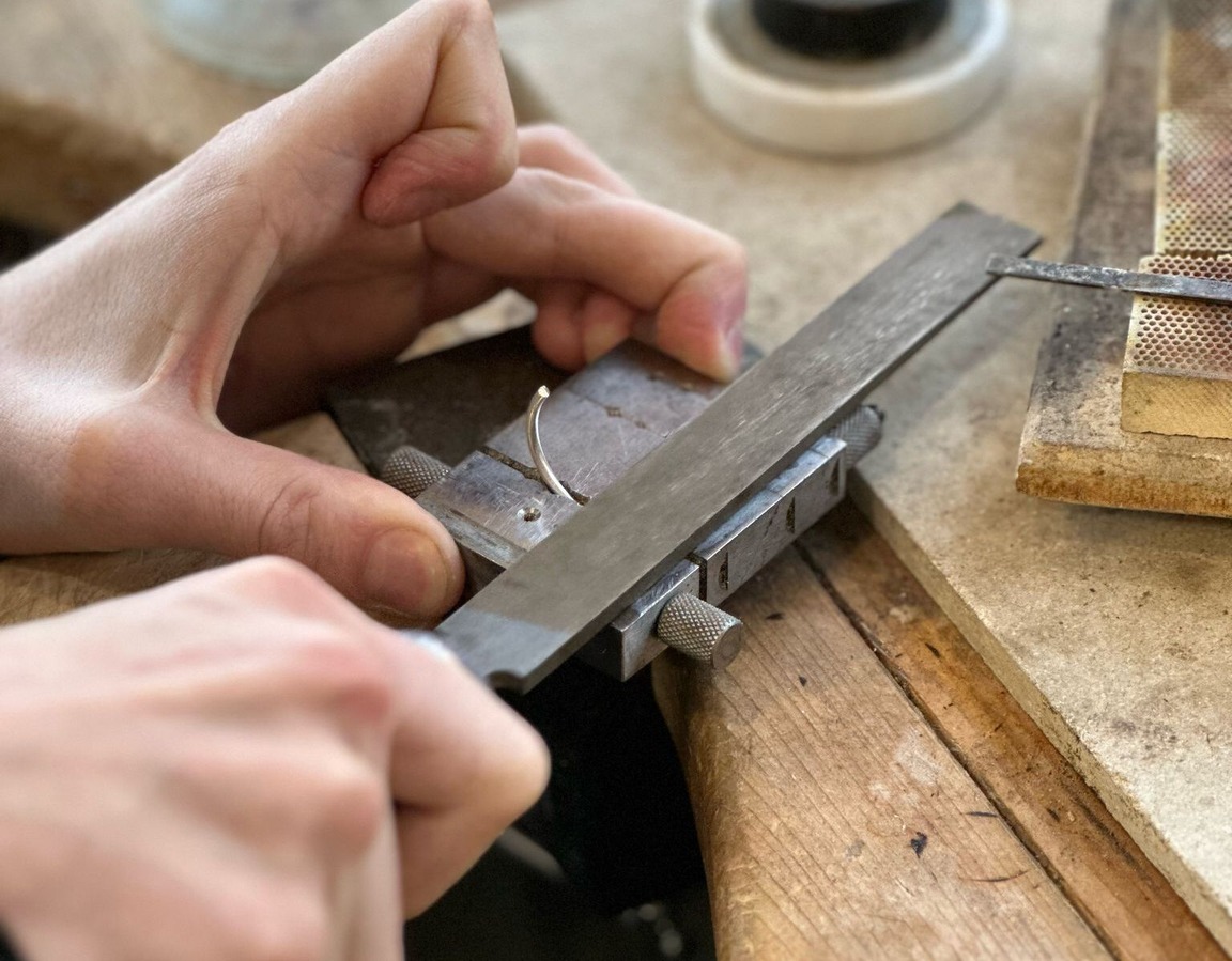 Jeweler crafting a piece at the workbench